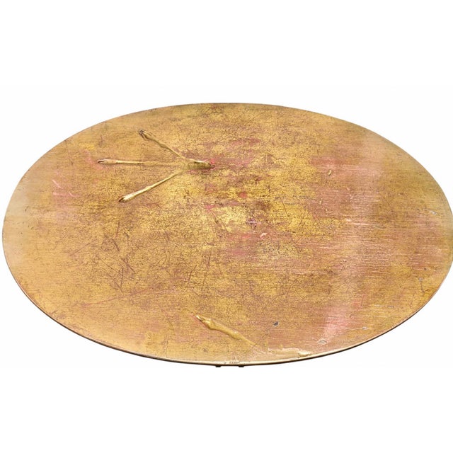 This rare and iconic table features a wooden top gilded with gold leaf, with traces of birds in relief on the surface. It...