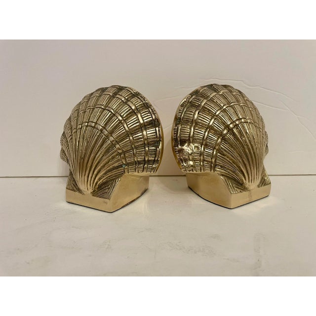 Pair brass clam shell seashell bookends. Good condition. Thin felt and "Made In Korea" stickers on bottoms Ready to use.