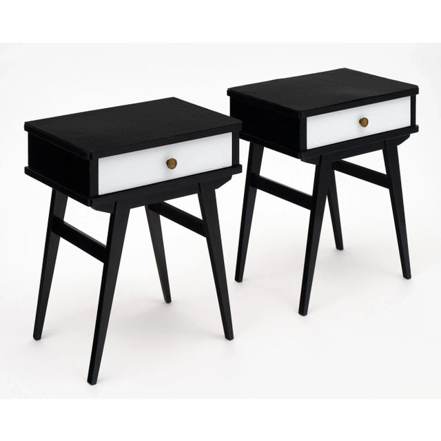 Pair of side tables from Italy that are veneered in black and white textured Murano glass. Each features one drawer with a...