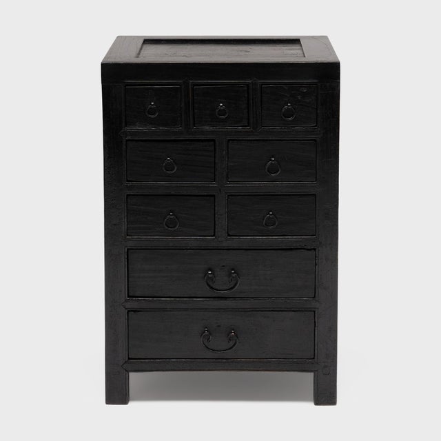 This low cabinet with many drawers is a small Chinese apothecary chest, once used in a 19th-century pharmacy to organize...