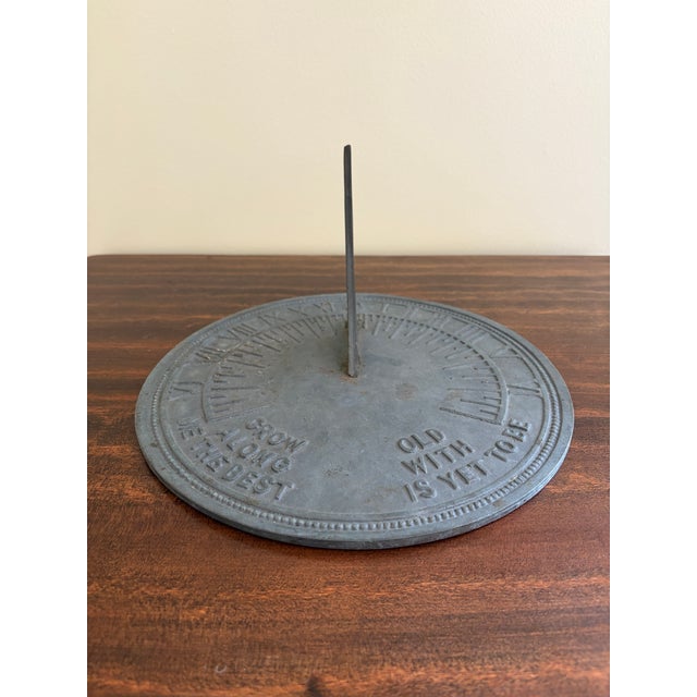 A classic vintage iron verdigris garden sundial inspired by traditional English estate landscapes, reading "Grow old along...