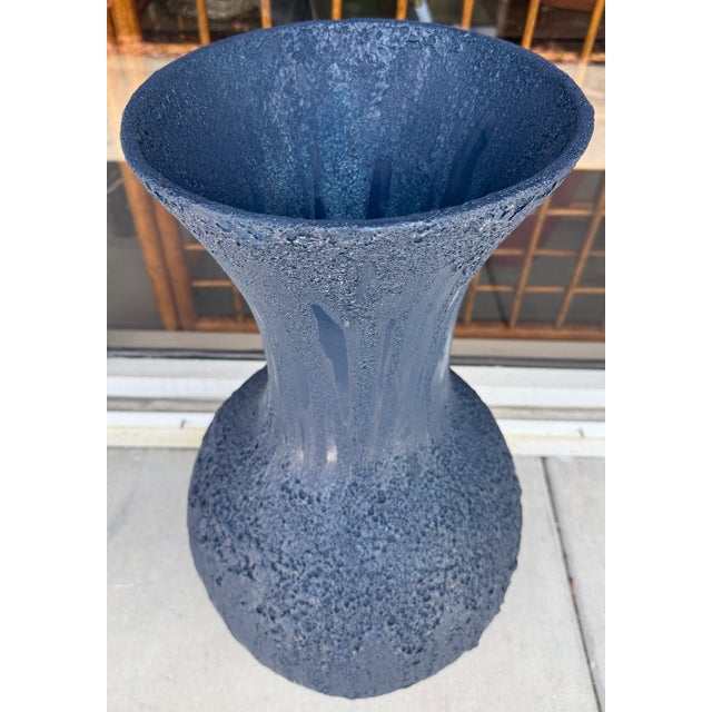 Mid-century modern studio art pottery vase finished in a heavily textured dark blue volcanic lava or pumice glaze. It...