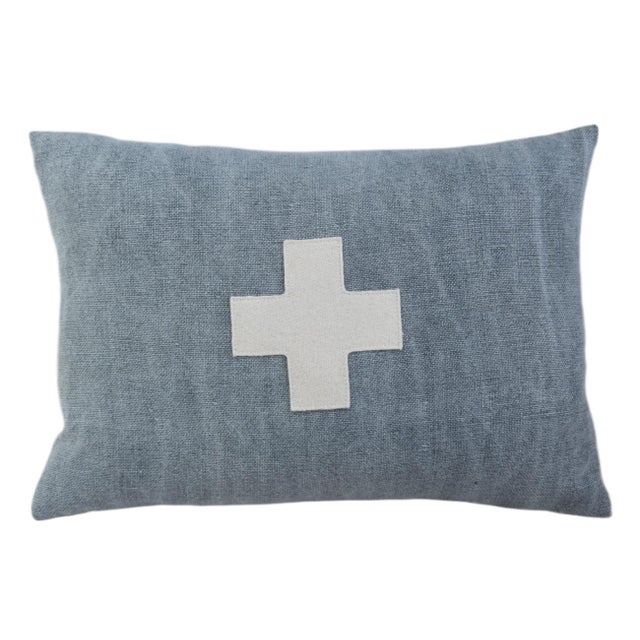 Custom-tailored pillow created from a blue woven cotton/linen textile. Pillow has a cream-colored wool appliqué cross on...
