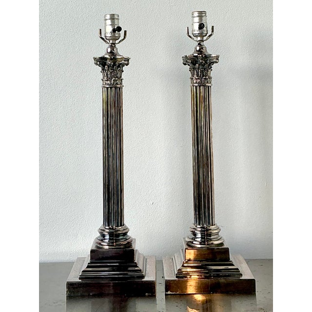 This majestic pair of English silver Corinthian column lamps is a masterclass in Neoclassical elegance and Hollywood...