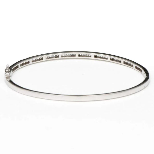 Glittering diamonds flow in a line along this attractive bangle bracelet. The 14K white gold in this lovely piece provides...