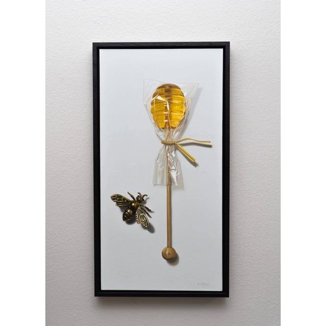 This artwork depicts a beautifully rendered honey dipper wrapped in clear plastic, accompanied by a detailed, golden bee....