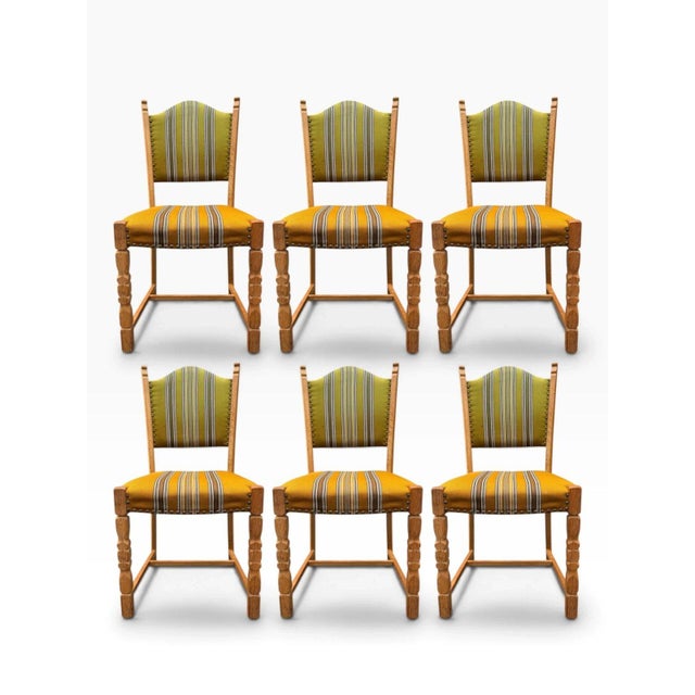 Here is a set of six Danish modern dining chairs designed by Henning Kjærnulf, with solid oak frames. They show his...