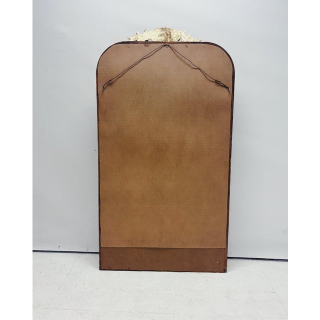 Large gold Baroque mirror with a richly decorated egg-and-dart frame and ornate crest. This beautiful vintage mirror is a...
