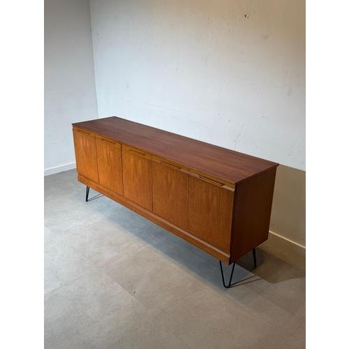 Mid-century modern sideboard produced by Meredew , crafted in beautifully grained teak wood and raised on elegant black...