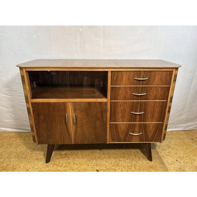 A stunning mid-century modern walnut sideboard and cocktail cabinet designed by františek jirák for tatra nábytok, dating...