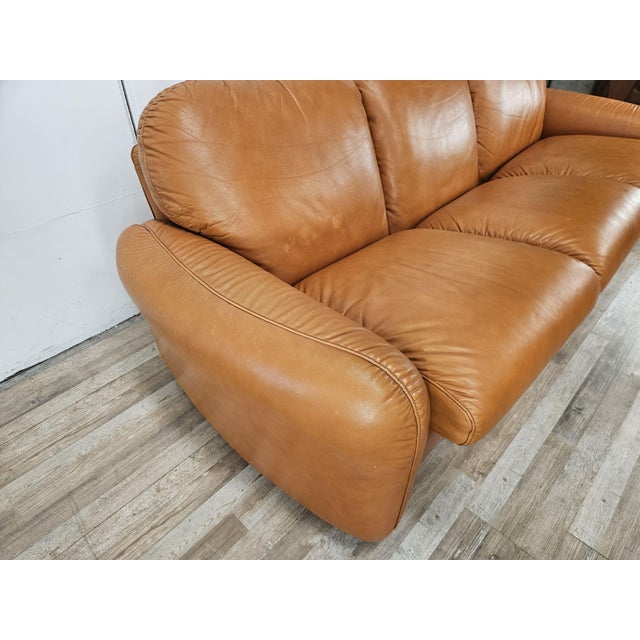 1970s orange leather sofa, Piumotto model, designed by Arrigo Arrigoni for Busnelli. The sofa features a three-seater...