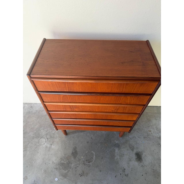 Vintage Danish Mid Century Modern teak tallboy dresser featuring elegant sculpted drawer pulls and tapered solid wood...