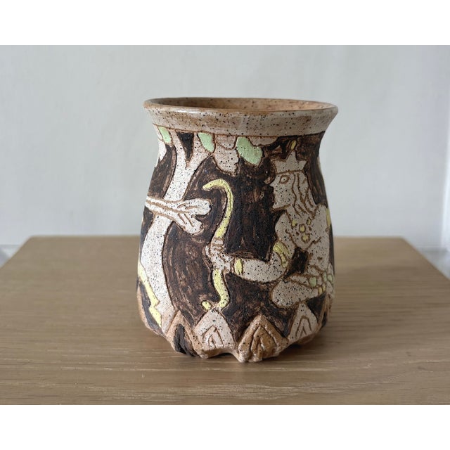 A sculptural American studio pottery bud vase from New York featuring an elaborate hand-incised and glazed woodland scene....