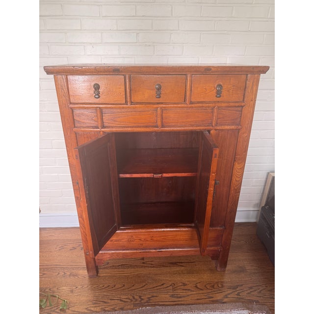 This classic Chinese elmwood cabinet in the traditional Qing dynasty style — from the late 19th century (1850–1900), which...