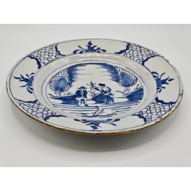 18th-Century Dutch Delft chinoiserie charger hand molded and hand painted in cobalt blue. It has a lovely scene with two...