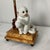 A whimsical and highly decorative pair of Chinoiserie-style table lamps, each featuring a charming seated ceramic monkey...