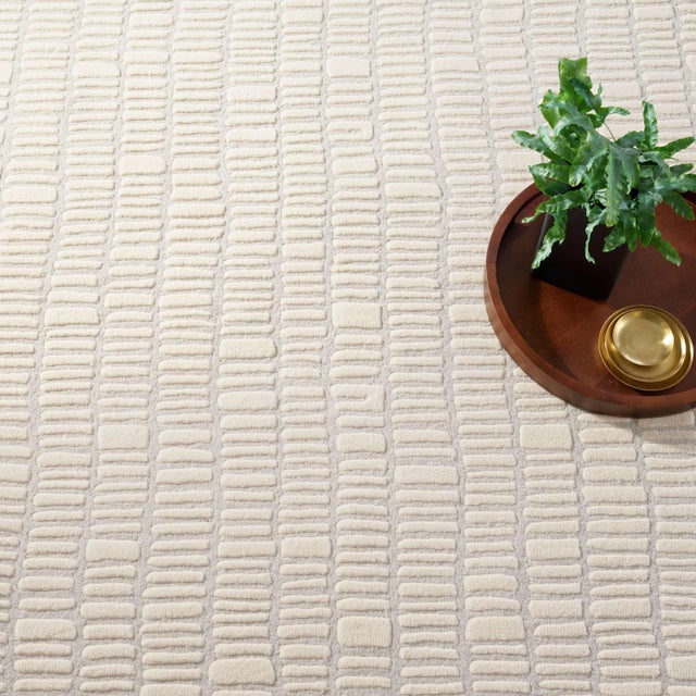 The rhythmical design of this luxurious, plush wool rug conjures surfaces of ancient hand-laid rock walls. The contrast...