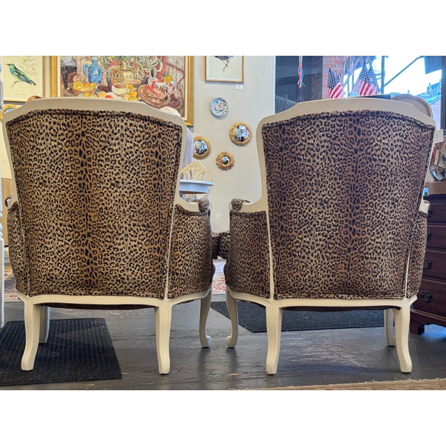 This is a pair of antique bergere side chairs. They are French style. They have a cheetah print fabric. They have been...
