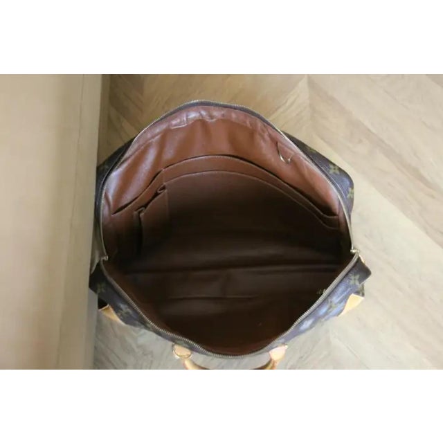 This Louis Vuitton Briefcase bag features Louis Vuitton monogram and cowhide leather, dual rolled leather top handles, one...