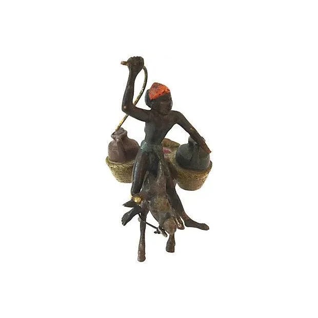 19th century Austrian miniature bronze figures of a donkey and two males. The hand of one figure is broken; originally...