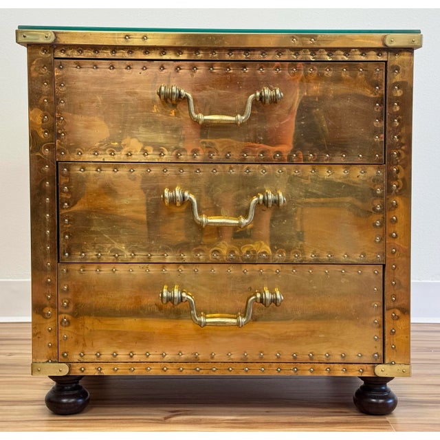 Vintage Sarreid, Ltd chest of drawers with a mirrored brass exterior and glass top. Features a polished finish with brass...
