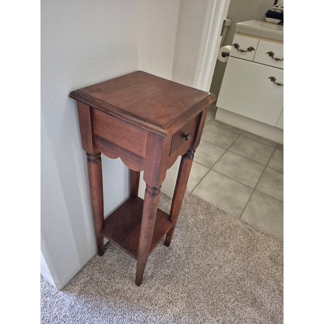 This is a vintage-style, square-topped wooden accent table featuring a rustic, dark-stained finish. Key Features: Top...