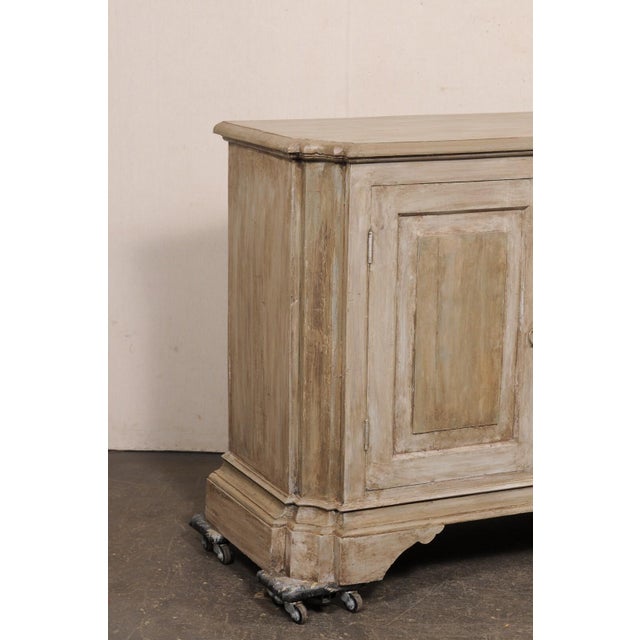 An Italian inspired, American made carved wood, two-door buffet cabinet. This vintage console cabinet has been beautifully...