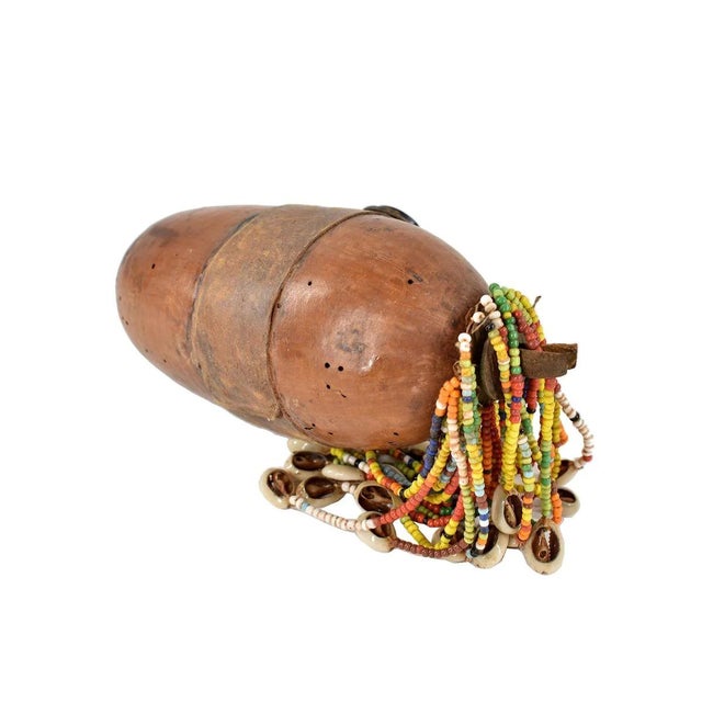 The Nyamwezi Beaded Fertility Doll Gourd with Shells from Tanzania is a stunning representation of fertility and...