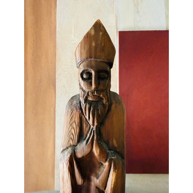A compelling vintage Mexican folk religious carving, hand carved in a tall, elongated form with a solemn, contemplative...