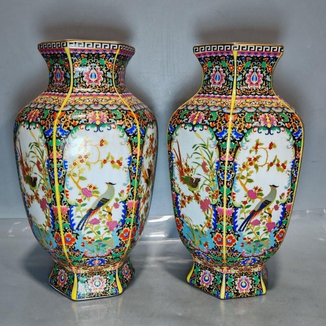 This magnificent pair of hexagonal porcelain vases showcases the intricate beauty of Famille Rose (Fencai) enamel...
