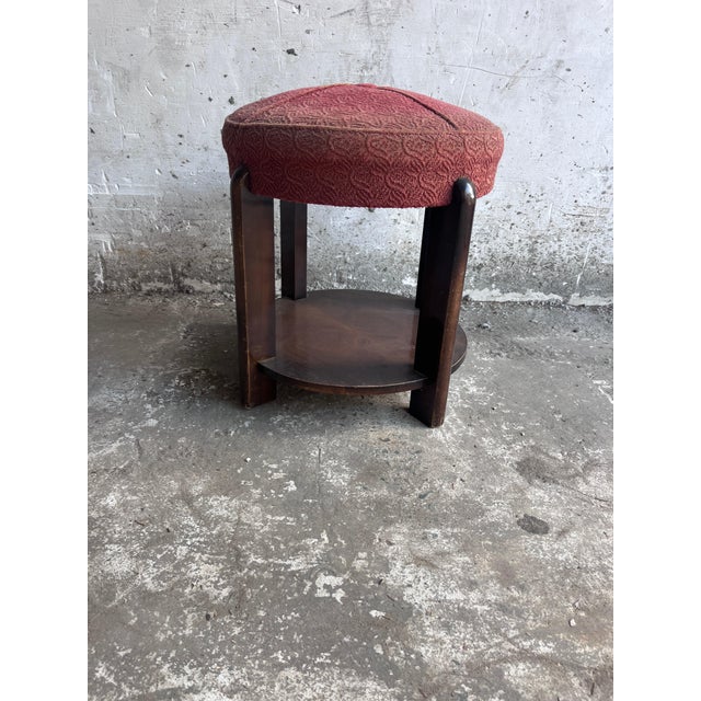 A charming French Art Deco stool dating from around 1930, combining a sculptural dark-stained wooden frame with a...