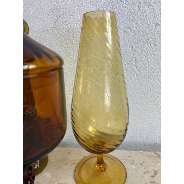 This is a collection of Italian Empoli Rossi glass. This glass collection has three covered jars with two vases. This...