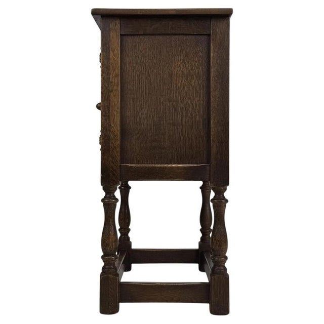A charming early 20th-century English chest of drawers, well crafted from golden oak and distinguished by its warm...