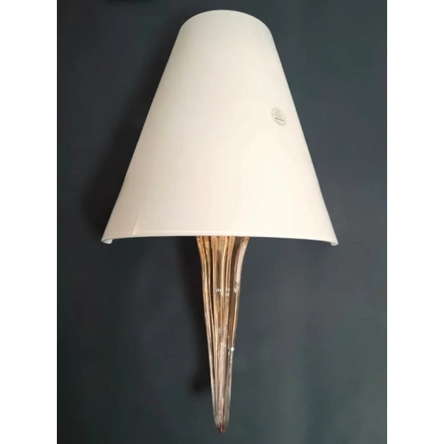 Vintage Italian Murano glass wall light with an opaque milky white shade and transparent pink stem mounted on white metal...