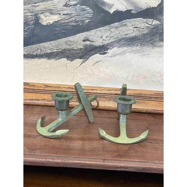 A pair of vintage decorative wall-mounted candle holders crafted in the form of anchors. Each piece features a stylized...