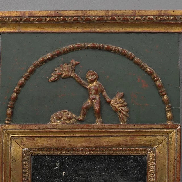 This Gustavian mirror is from the 17th or 18th century. It is made of painted and gilded wood with figures, featuring old...