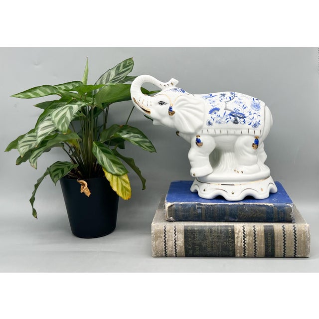 Equisite and substantial porcelain elephant figurine featuring a classic blue and white Chinoiserie–inspired floral motif,...