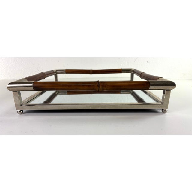 This is a nickel plated and bamboo galley tray. This square tray has a nickel plated frame standing on four bun feet with...