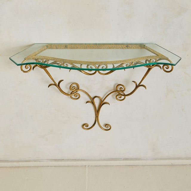 An Italian wall-mounted console from the 1950s, in the manner of Pier Luigi Colli. The frame is forged in gilt iron, its...