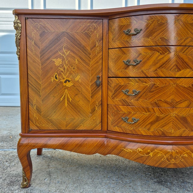 This is an elegant Louis XVI style sideboard cabinet with marble top and faux marquetry. The sideboard measures 59.5”...