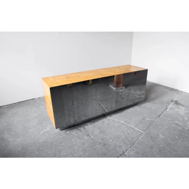 A stunning Paul Evans cabinet or credenza adorned in figural burl veneer and mirrored chrome tiles at the back. The...