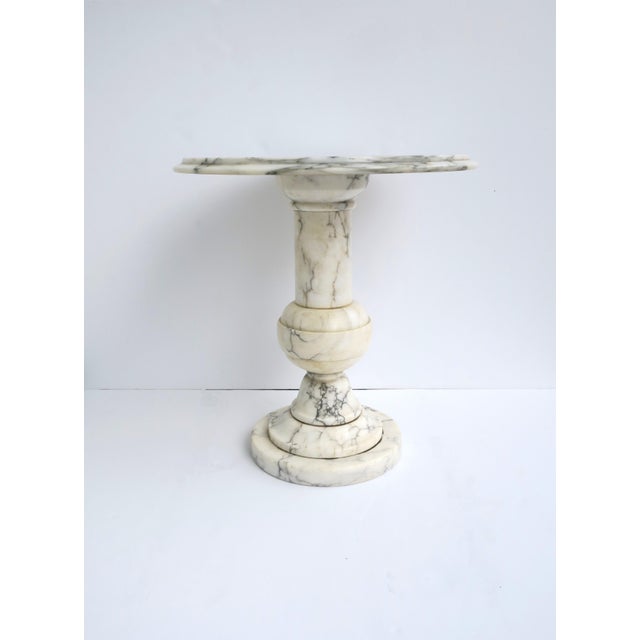 A substantial Italian round marble side or drinks table, circa mid-20th century, Italy. Marble is predominantly white with...