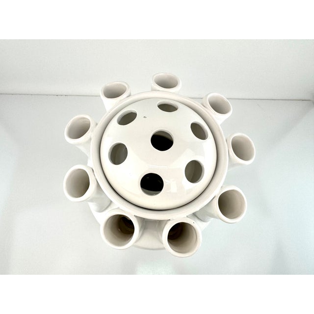 This vintage white ceramic flower frog vase features a sculptural pedestal form designed to hold multiple stems in an...