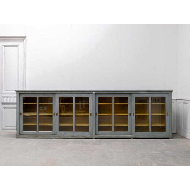 A true statement piece, this very large glass-fronted sideboard has been entirely preserved in its original patina. with...