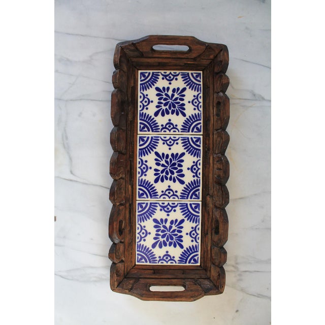 Vintage hand carved wood tray with three blue and white ceramic tiles. No makers mark. Minor age wear. No chips or cracks.
