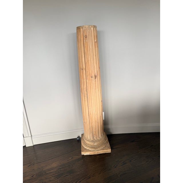 A pair of architectural columns in the neoclassical Doric style. Each column has a fluted shaft and a stepped square base...