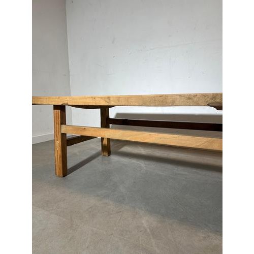 Characterful vintage wooden coffee table with a thick plank top and sturdy trestle-style base. The tabletop shows...