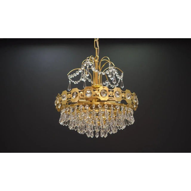 The chandelier was made in the 1970s, Danish production. Made from a combination of brass and glass. Condition: Chandelier...