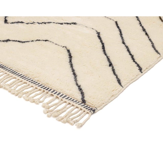 Refined hand-knotted wool rug with an Ivory base and contrasting Midnight Black asymmetrical chevron patterns, infusing a...