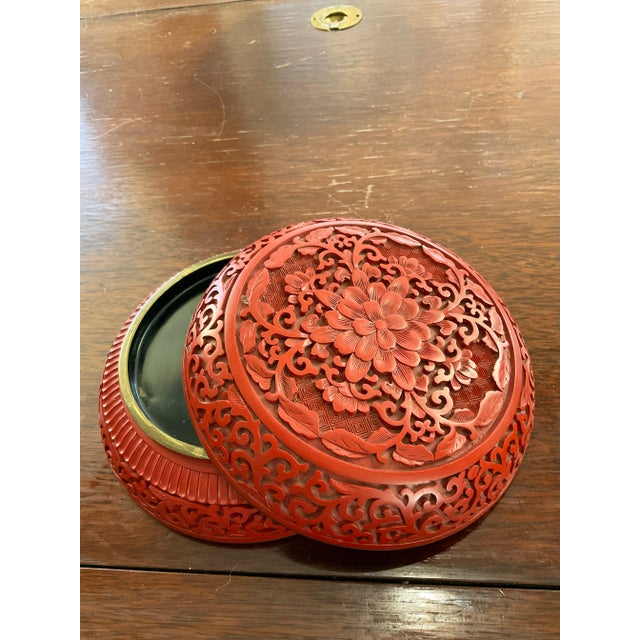 This is a large, beautiful cinnabar box. It is very intricately caved with a chrysanthemum on top and scrolls on the...